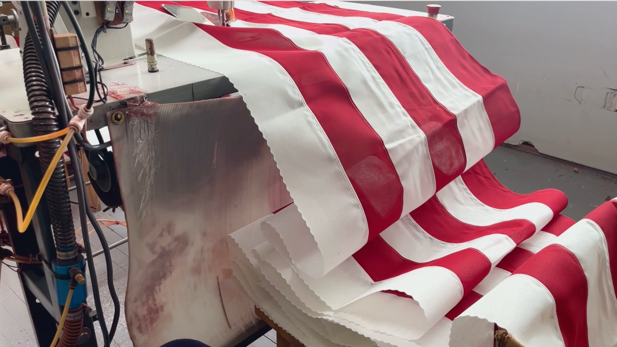 Close-up of red and white stripes of an American flag being sewn together at Allied Materials factory in Kansas City, Missouri.